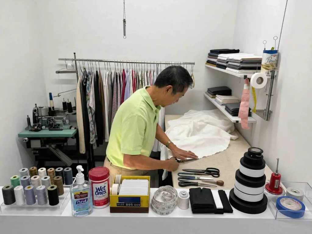 Mr Lee Super Cleaners tailor cutting fabric for alterations